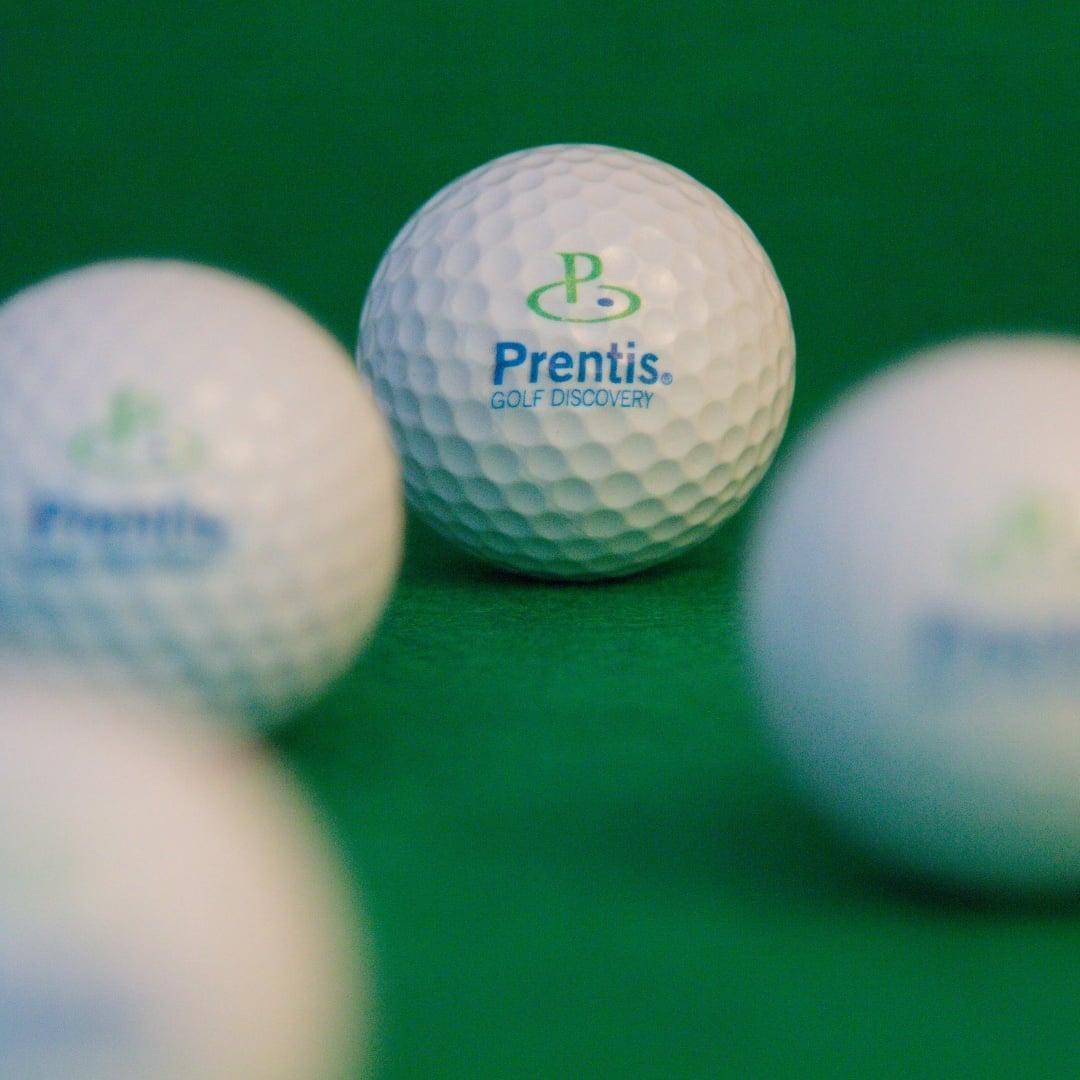 Three Prentis Golf balls on a green practice mat